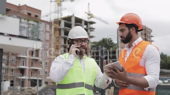 工程师在施工现场用手机讲话检查工人的工作情况关于智能手机的讨论视频的预览图