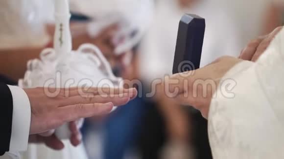 牧师在婚礼上在教堂祈祷并为新婚夫妇戴上戒指视频的预览图