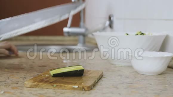 厨房餐桌上的砧板上女性手切黄瓜的特写敲刀视频的预览图