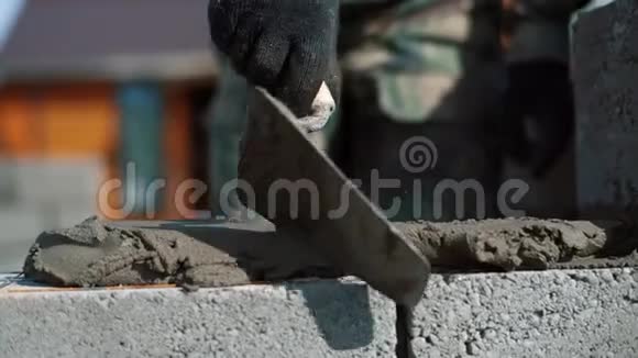 建筑工人放置水泥砂混合物以便进一步铺设砌块视频的预览图