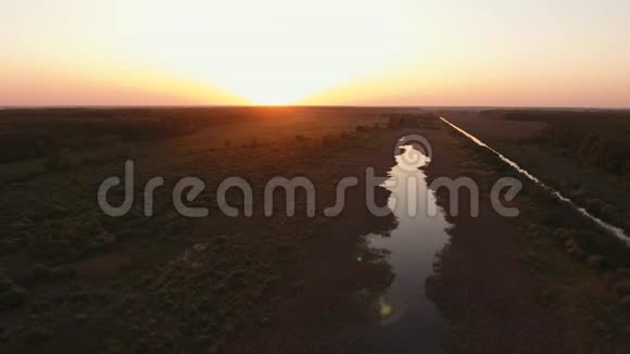 日落时分在河上的无人机上飞行摄像机向左飞日落时分的森林视频的预览图