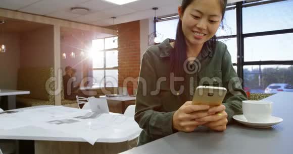 女高管在喝咖啡时使用手机视频的预览图