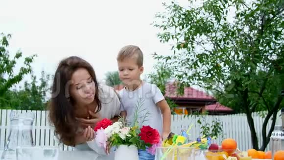 夏天在花园里妈妈和一个四岁的儿子做了一束花这个男孩非常喜欢它玩得很开心视频的预览图