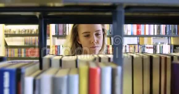 女学生在学校图书馆书架间散步视频的预览图
