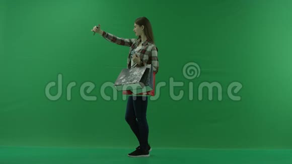 穿着购物袋的女孩站在左边在绿色屏幕上自拍视频的预览图