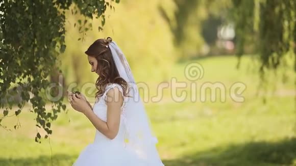 一位美丽的新娘和英俊的新郎在桦树林里快乐在一起的肖像新郎来到新娘的身后视频的预览图
