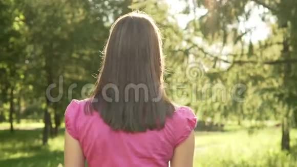 慢动作Pov女在公园散步放松暑假转身微笑后面的摄像头视频的预览图