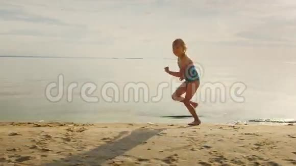 无忧无虑的金发女孩沿着海岸跑了5年他笑她的脚飞了很多水溅视频的预览图