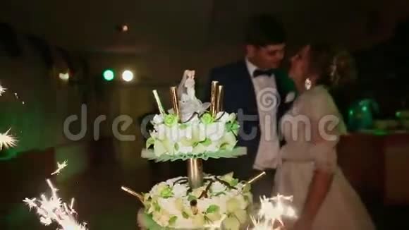 婚礼上的新娘和新郎用燃烧的孟加拉灯看着蛋糕视频的预览图