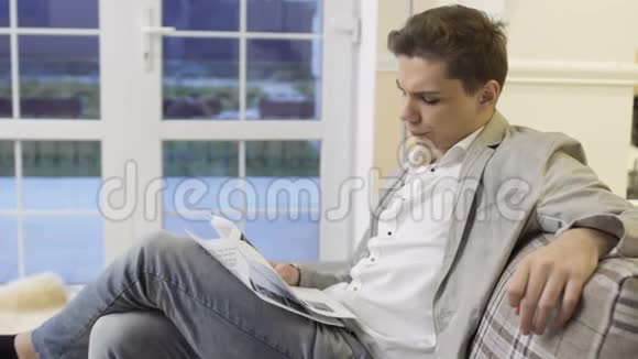 年轻人坐在沙发上看文件视频的预览图