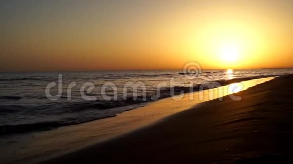 平静缓慢令人满意的海浪拍打在沙滩上海洋海岸海岸线在庄严温暖的傍晚橙色的日落海景视频的预览图