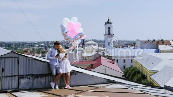 电影院年轻夫妇拿着气球坐在屋顶上视频的预览图