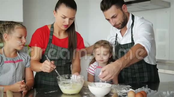 幸福的家庭一起做饭年轻的女儿正在帮助他们的父母他们玩得很开心视频的预览图