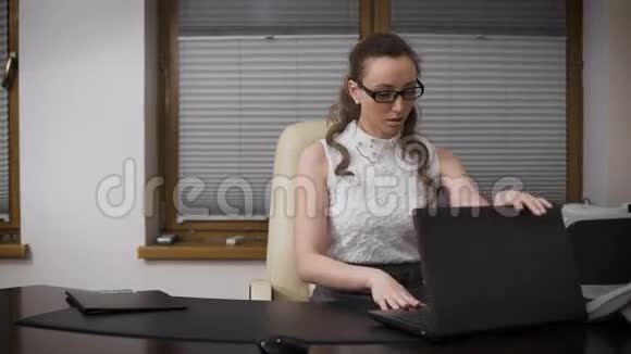 年轻的商务女性在办公室放松得起她双腿交叉在桌子上她梦想着长大视频的预览图