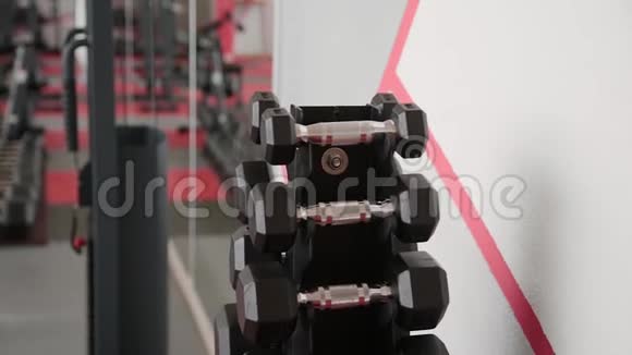 训练用的哑铃躺在健身房的架子上视频的预览图