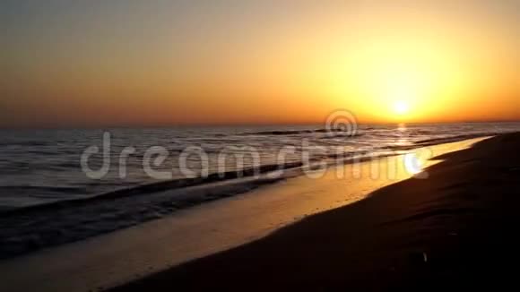 夕阳西下夕阳西下的天际线平静而令人满意的海浪拍打在沙滩海岸上视频的预览图
