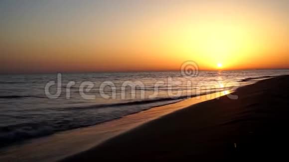 在美丽的黄昏夕阳天际线下沙滩海岸的海浪拍打着平静而令人满意的时光流逝视频的预览图