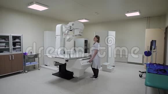 现代化的新型医疗办公室里面有各种电子设备一位女医生调整X光机使之工作视频的预览图