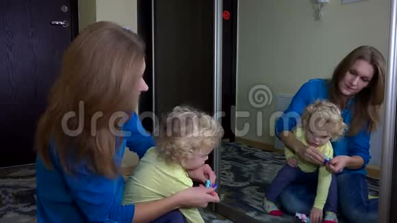 可爱的女人把她女儿的头发塞进去视频的预览图