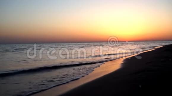 在温暖的黄昏粉红色的日落海景中在沙滩海洋海岸海岸线上缓慢而令人满意的平静海浪拍打着视频的预览图