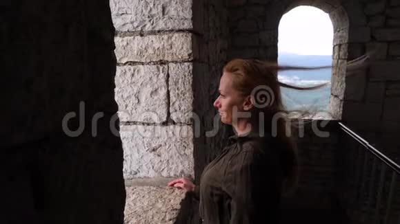 那个女人正在看塔的窗户风吹在她的头发上4k慢动作视频的预览图