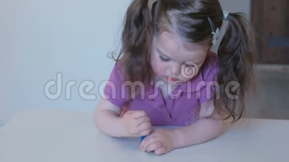 小可爱的女孩用蓝色清漆涂指甲视频的预览图