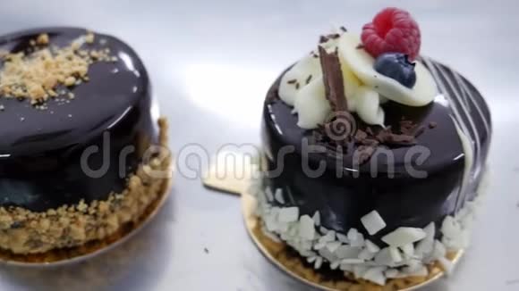 一个移动镜头显示两个装饰好的单份蛋糕躺在桌子上镜头从左到右移动视频的预览图