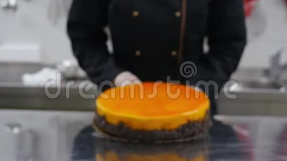 一个糖果师把一个新鲜的橘子蛋糕推到桌子的前面视频的预览图