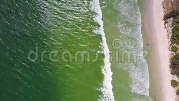 驾驶飞机飞越绿海洗涤货运船只驶往海滩视频的预览图