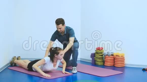 这个女孩在诊所里和教练一起做恢复运动视频的预览图
