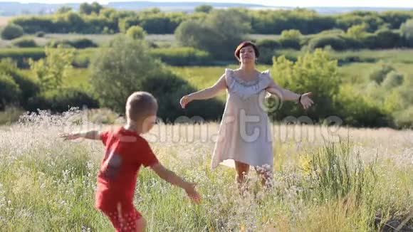 一个阳光明媚的夏天在一个村庄一个女人带着一个孩子在草地上休息视频的预览图