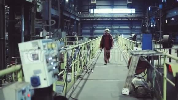 工厂里的工人去他们的工作场所在他手中的智能手机里视频的预览图