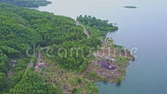 飞行摄像头显示安静的河流与热带森林和道路的河岸视频的预览图