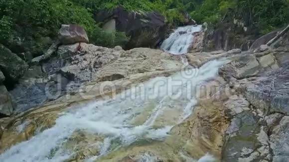 镜头显示冰冷的瀑布瀑布在岩石上流淌视频的预览图