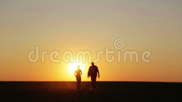 日落时分一对夫妇跑着跳进了田野视频的预览图