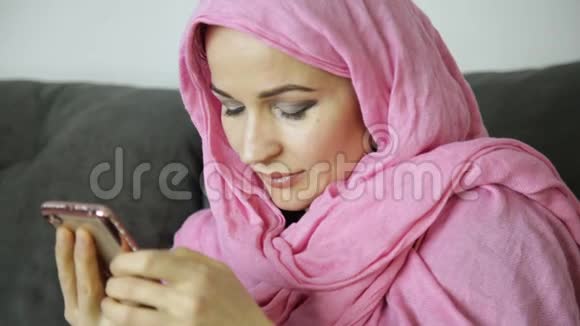 年轻的穆斯林妇女正在和她的朋友聊天戴着头巾的阿拉伯女人手里的手机视频的预览图
