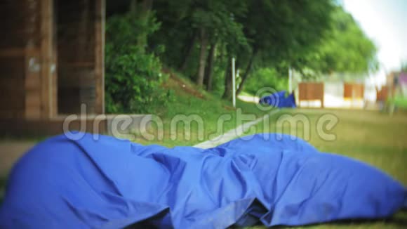 年轻女子躺在公园的一个休息区软软的泡芙上视频的预览图