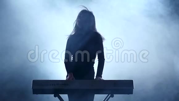 喜欢弹钢琴的女人在烟雾中跳舞慢动作视频的预览图