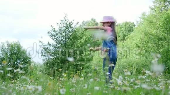 在草地上在雏菊中在草地上跳舞跳跃玩得很开心一个漂亮的女孩大约七岁她是视频的预览图
