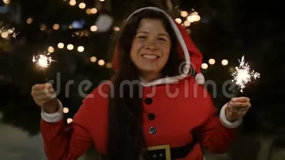 穿红色毛衣的快乐女人拿着烟花圣诞节的概念视频的预览图
