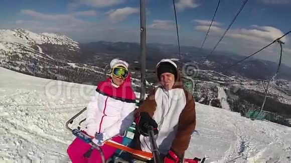 在阳光明媚的日子里快乐的滑雪者在滑雪缆车上山视频的预览图