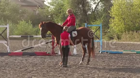 小女孩在农场和教练一起学习骑马视频的预览图