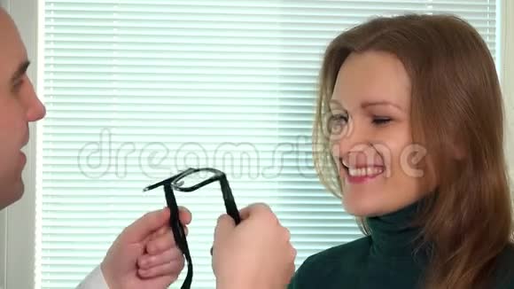 年轻的黑发女子配眼镜医生男子试眼镜视频的预览图