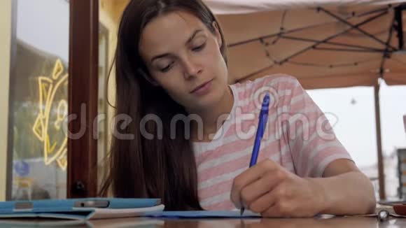 坐在咖啡馆里学习的年轻女子学生作业视频的预览图