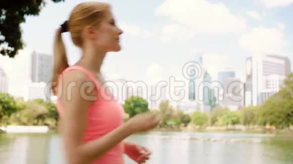 女子跑步者在公园慢跑适合女性运动健身跑步训练听智能手表音乐视频的预览图