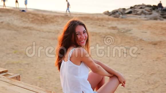 快乐的年轻女子在早晨的海滩上笑视频的预览图