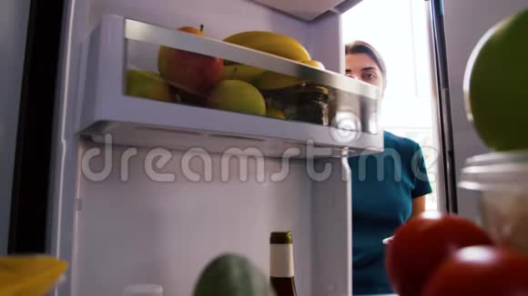 在家庭冰箱里做必要食物清单的女人视频的预览图