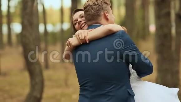 结婚纪念日新娘拥抱新郎在松树林里爱的一对看着对方视频的预览图