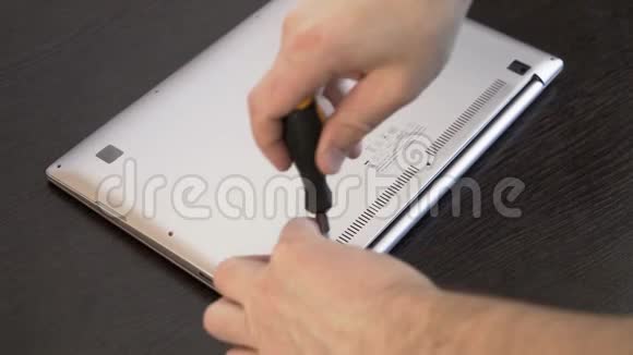 主人移除笔记本电脑的后盖双手用螺丝刀特写电脑维修视频的预览图