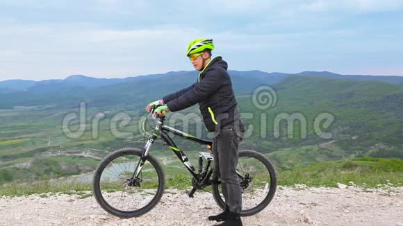 一个人一个游客离开自行车上的车架可以看到山地地形视频的预览图